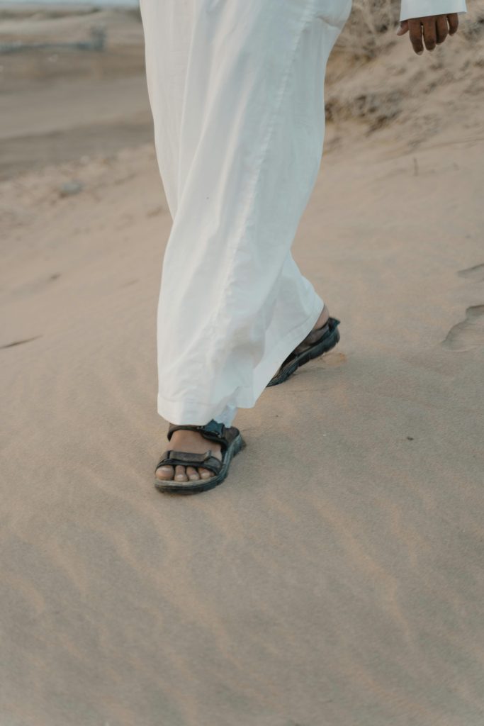 Caminando con sandalias por la playa